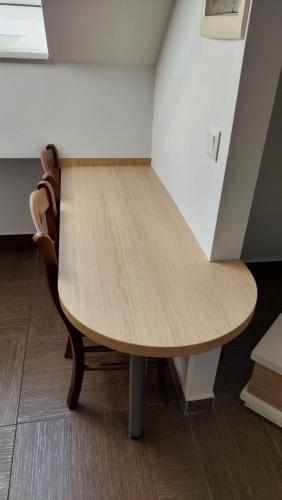 a wooden table and chair in a room at Apartma Samo 3 in Kranj