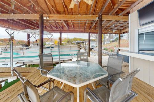 una mesa y sillas en una terraza con un barco en Lake Escape, en Moneta
