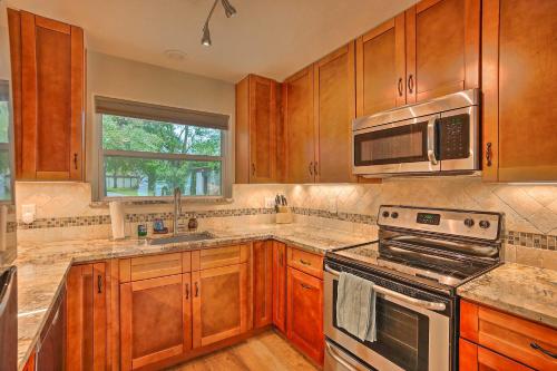 a kitchen with wooden cabinets and stainless steel appliances at Modern Lake Conroe House with Lakefront Park and Deck! in Willis
