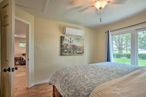 a bedroom with a bed with a ceiling fan and a window at Modern Lake Conroe House with Lakefront Park and Deck! in Willis