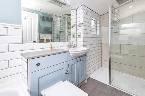 ein Bad mit einem Waschbecken und einer Dusche in der Unterkunft Lovely 2-bedroom maisonette in Windsor in Windsor