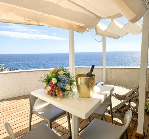 a table with a bouquet of flowers on a balcony at La Ripa Camere Vernazza - The Spinnaker Suite in Vernazza