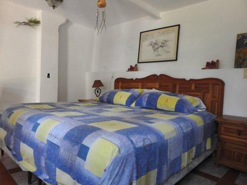 a bedroom with a blue and white bed with a blue and yellow blanket at Habitación independiente a pie del lago con AC in Tequesquitengo