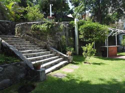 a set of stone stairs in a garden at Habitación independiente a pie del lago con AC in Tequesquitengo