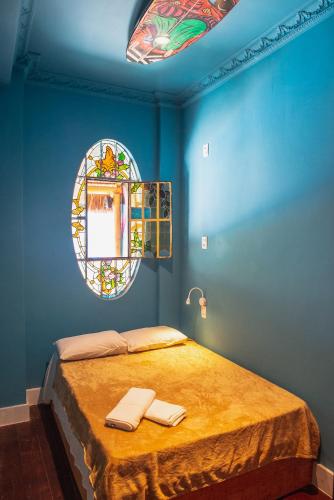 a blue bedroom with a bed and a mirror at Longboard Paradise Surf Club in Rio de Janeiro