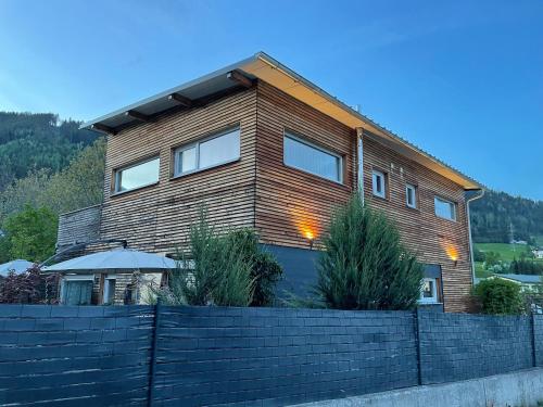 a wooden house with a fence in front of it at Chalet Maya in Schladming