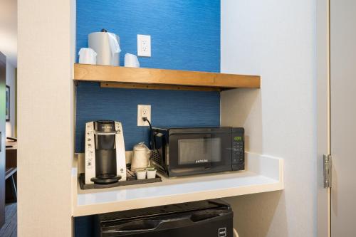 a microwave sitting on a shelf in a kitchen at Holiday Inn Express Grover Beach-Pismo Beach Area by IHG in Grover Beach