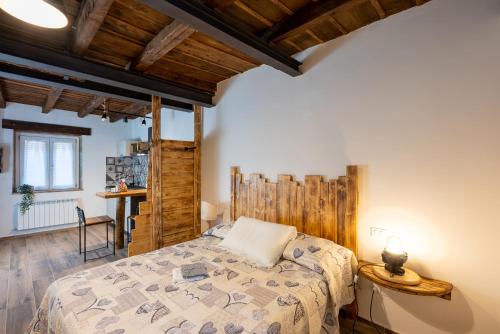 安科納的住宿－La Rosa del Borgo，一间带一张床的卧室,位于带木制天花板的房间内