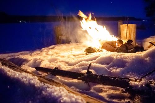a fire pit in the snow at night at Hugsnäset Semesterstugor och Fiske in Gällö
