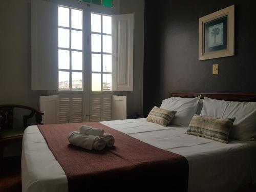 a bedroom with a large bed with a towel on it at Hotel Casa Grande Itapira in Itapira