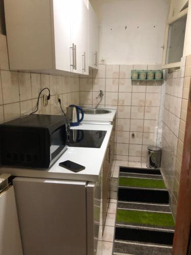 una pequeña cocina con fregadero y microondas en Apartment Lameram, en Sarajevo