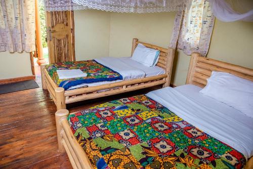 two twin beds in a room with at Elite Backpackers Services in Masaka