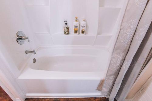 a white bath tub with two bottles on top of it at Lavender Castle in Sequim