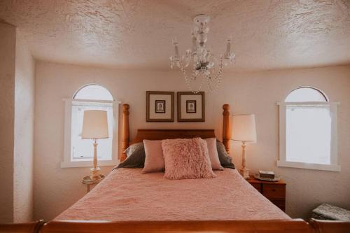 a bedroom with a large bed with two windows at Lavender Castle in Sequim
