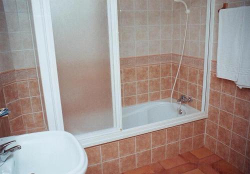 a bathroom with a shower and a toilet and a tub at Pensión Restaurante Venta El Molino in Sopalmo