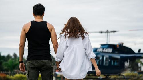a man and woman holding hands while looking at a helicopter at Domus Glamping Guatapé in Guatapé