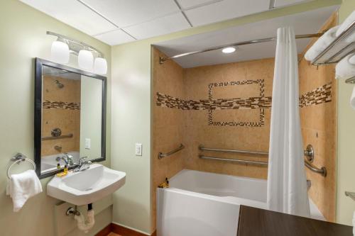 a bathroom with a tub and a sink and a shower at Sandcastle Resort in Virginia Beach