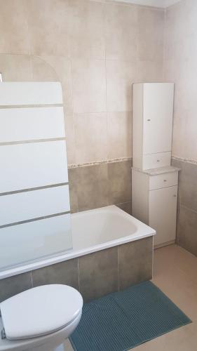 a bathroom with a tub and a toilet and a refrigerator at Casa Lavanderas in Algodonales