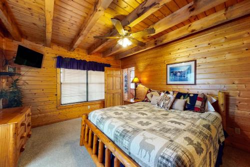 ein Schlafzimmer mit einem Bett in einem Blockhaus in der Unterkunft Fox Hollow in Little Cove