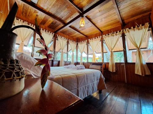 Sotupa Eco Lodge في بويرتو مالدونادو: غرفة نوم بسرير في غرفة بسقوف خشبية