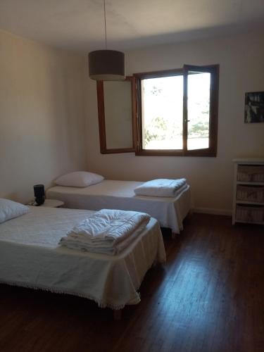 une chambre avec deux lits et une fenêtre dans l'établissement Maison à la campagne, à Duffort