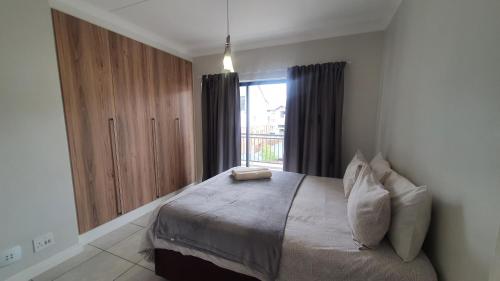 a bedroom with a large bed and a window at The Blyde Crystal Lagoon One Bedroom Apartment in Pretoria
