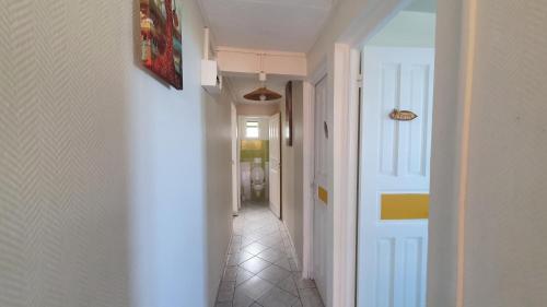 a hallway with a white door and a tile floor at Villa Campêche in Bouillante
