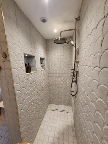 a bathroom with a shower with white tiled walls at Unique and beautiful property in a quiet location. in Nottingham