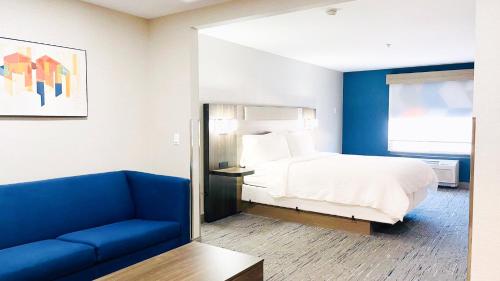 a hotel room with a bed and a blue couch at Holiday Inn Express & Suites Frazier Park by IHG in Lebec