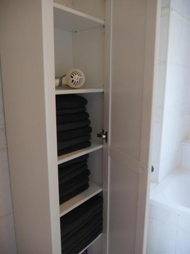 ein Schrank mit schwarzen und weißen Handtüchern auf Regalen in der Unterkunft Maisonette-Wohnung in Nürnberg mit Kamin in Nürnberg