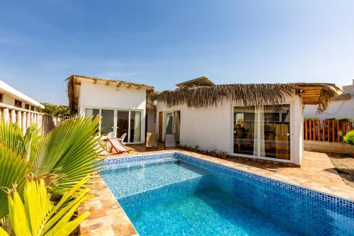 a swimming pool in front of a house at Casa Killa Vichayito in Vichayito