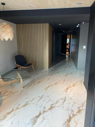 a lobby with marble flooring and a chair in a room at EUGE Apart in Montevideo