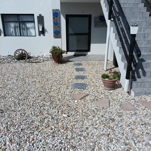 a gravel yard with a staircase and a house at Intimi2 in Yzerfontein