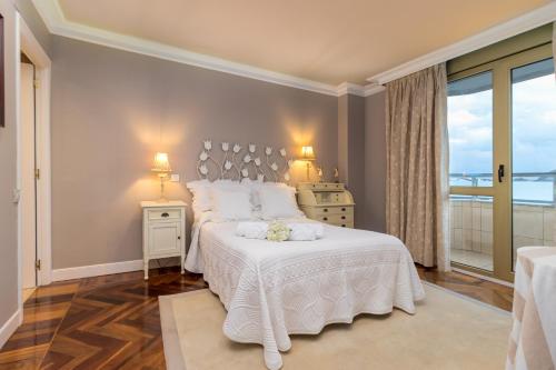 um quarto com uma cama branca e uma janela em Apartamento Junto Playa Sardinero Con Parking em Santander