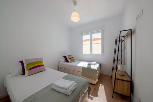 um quarto branco com 2 camas e uma janela em 2 bedrooms 1 bathroom furnished - Delicias - bright - MintyStay em Madri