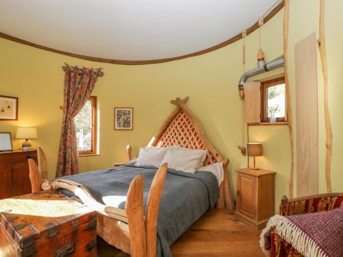 sypialnia z łóżkiem z drewnianym zagłówkiem w obiekcie The DugOut w mieście Hereford