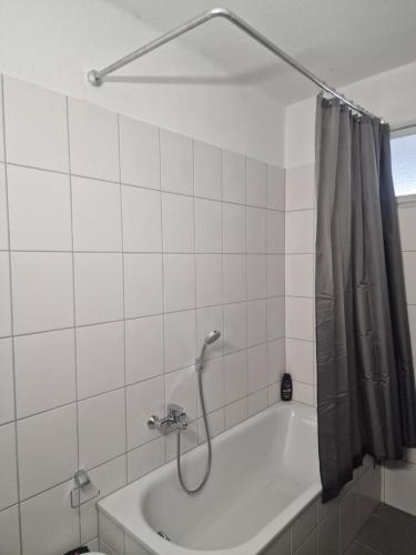 a bathroom with a bath tub with a shower curtain at Ferienwohnung Wunderlich gelb in Münchberg