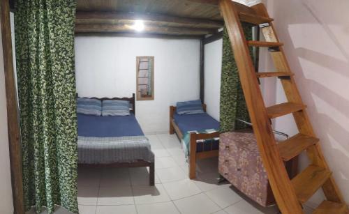 a room with a bunk bed and a ladder at Casa de Praia in Ilhabela