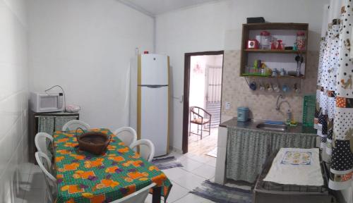 a kitchen with a table and a refrigerator at Casa de Praia in Ilhabela