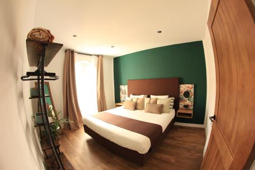een slaapkamer met een bed en een groene muur bij Arco León in León