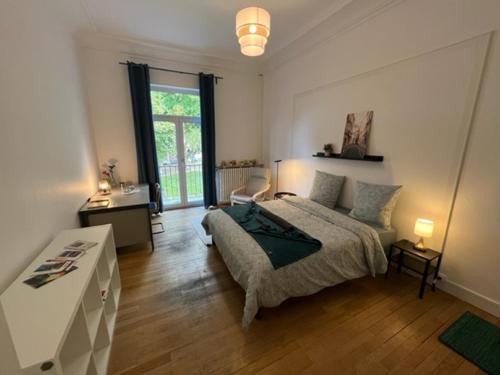 una camera con letto e scrivania di Chambres privées -Private room- dans un spacieux appartement - 100m2 centre proche gare a Mulhouse