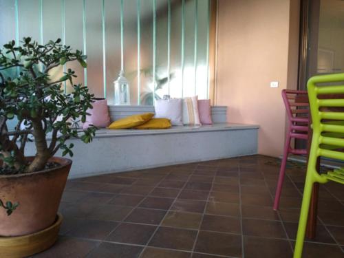 a room with a bench with pillows and a plant at Mi AN HOME in Paese