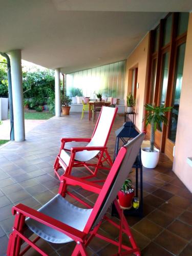 a group of red chairs sitting on a patio at Mi AN HOME in Paese