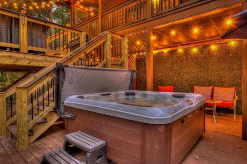 a jacuzzi tub on a deck with a staircase at Golden Eagle GA Cabin - Hot Tub, Firepit & Fast WiFi in Blue Ridge