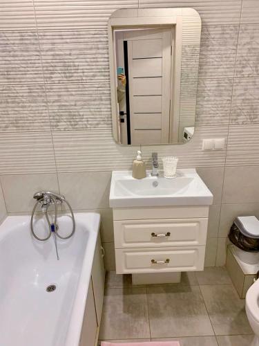 a white bathroom with a sink and a mirror at Sunny Home in Oral