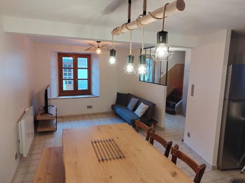 - un salon avec une table en bois et un canapé bleu dans l'établissement Agréable maison au centre d'Arreau pour 8 pers, à Arreau