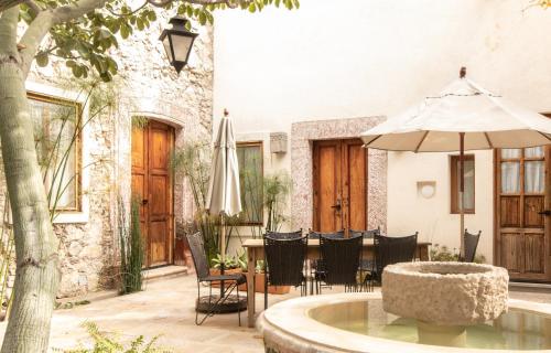 a patio with a table and an umbrella and chairs at Orchid House San Miguel de Allende in San Miguel de Allende