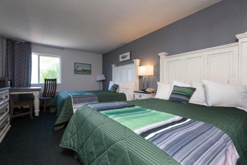 Habitación de hotel con 2 camas y escritorio en Buffalo Lodge, en Buffalo