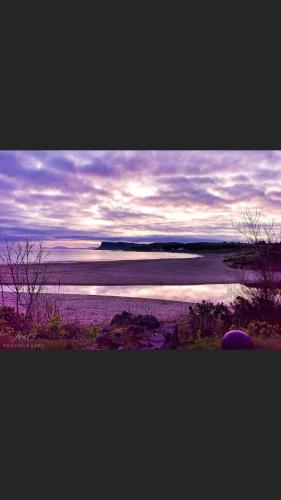 a view of a beach with the ocean in the background at Cosy Loft Apartment in Ballycastle