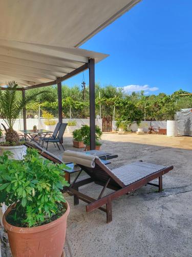 a patio with a picnic table and chairs under a pavilion at Evaggelias Home Gavalochori in Gavalochori
